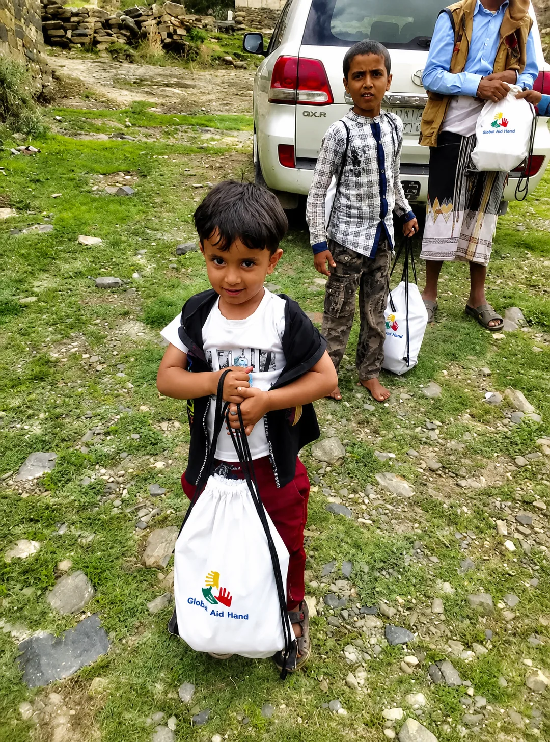 Yemeni children receiving Global Aid Hand school kits in a remote mountain village